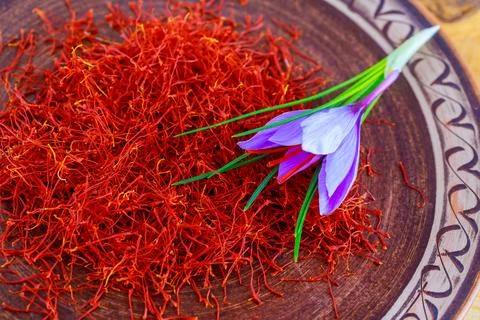 Dried saffron with a flower in a patterned ceramic plate. Stock Photos