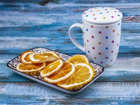 Dried slices of oranges on a rectangular plate and a cup for a drink from them Stock Photos