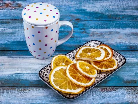 Dried slices of oranges on a rectangular plate and a cup for a drink from them Stock Photos