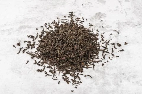 Dried tea is piled on a marble table. Stock Photos