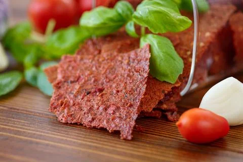 Dried tomato sheets with fresh vegetables on wooden background Stock Photos