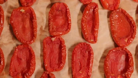 Dried tomatoes on an oven tray. The process of preparing an Italian appetizer Stockbeeldmateriaal 212949612