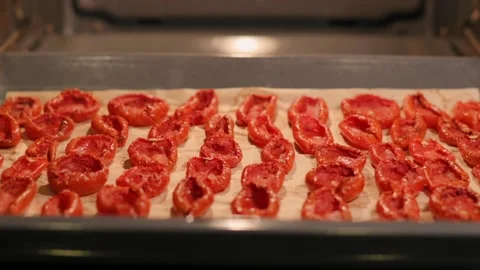 Dried tomatoes on an oven tray. The process of preparing an Italian appetizer Stockbeeldmateriaal 217982732