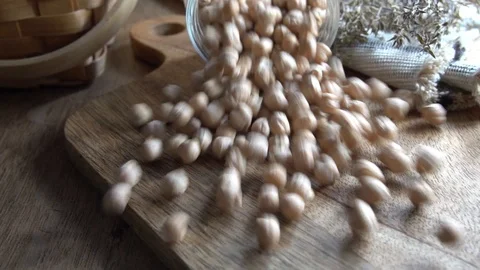 Dried uncooked chickpeas falling in slow motion over the table from a jar. Video stock 124286709
