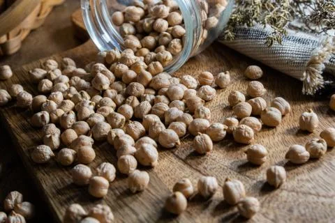 Dried uncooked chickpeas spread on table. Stock Photos