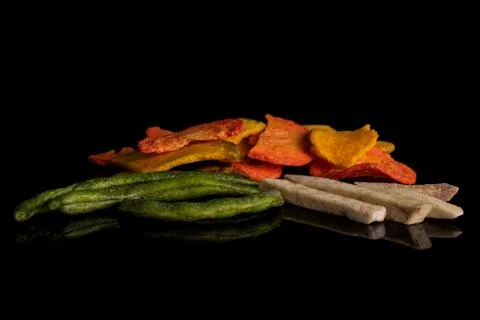 Dried vegetable chips isolated on black glass Stock Photos
