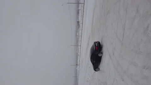 Drift on a black car on a background of white snow. (vertical video) Stock Footage 147491923