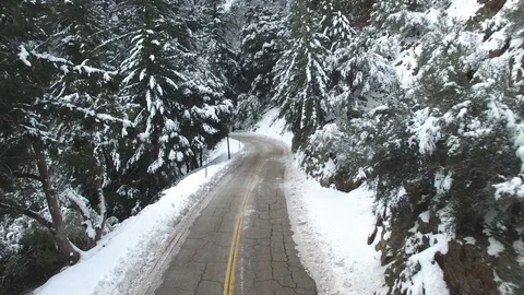 Drifting along Tree Lined Road in Snow Covered Mountains of California Stock Footage 71292798