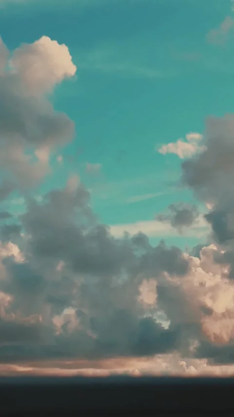 Drifting Clouds Glide Across a Blue Sky at Sunrise or Sunset Stock Footage 341527327
