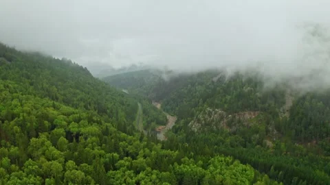 Drifting clouds gracefully flowing over a serene mountain valley Видео 302255002