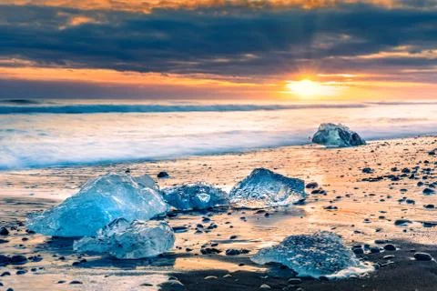 Drifting ice blocks on Diamond beach, at sunset, in Jokulsarlon, Iceland Stock Photos