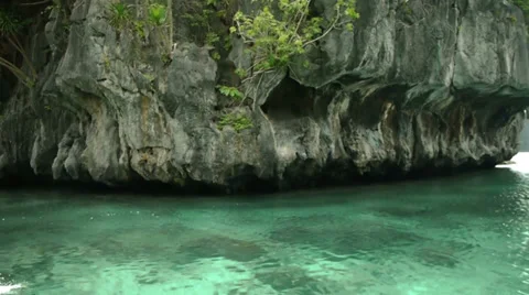 Drifting past limestone cliffs rising from calm, clear waters. Stock Footage 32187246