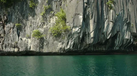 Drifting past limestone cliffs rising from calm, clear waters. Stock Footage 32187263