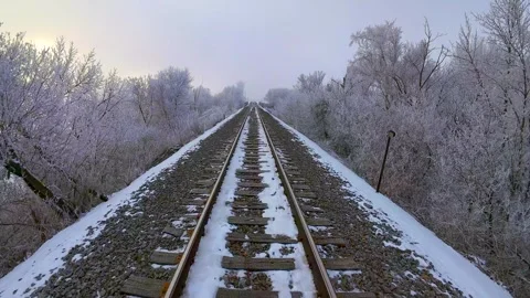 Drifting slowly down, railroad tracks through surreal frosted landscape Stock Footage 299378494
