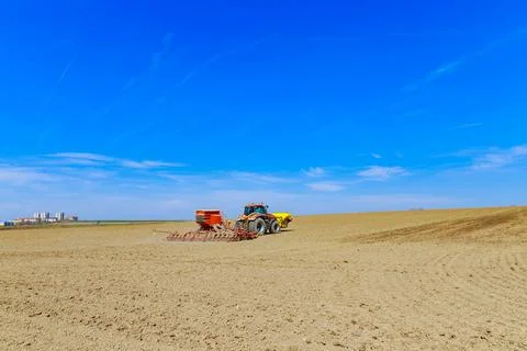 The drill is attached to the tractor, sows the field with grain. Stock Photos