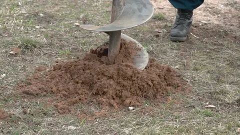 Drill bit for drilling soil close up. Drilling a hole into ground at a Stock Footage 186189572
