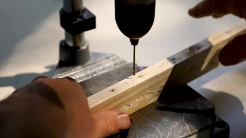 The drill bit drills a wooden block. Male hands. Close-up. Stock Footage 244936154