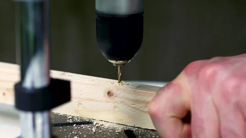 The drill bit drills a wooden block. Male hands. Close-up. Stock Footage 244936171