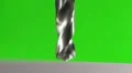 The drill bit make a hole in the metal on a green background. Slow motion HD Footage