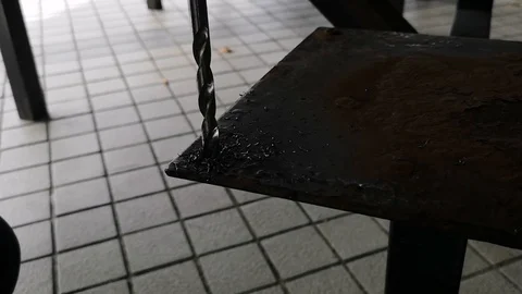The drill bit is rotating to punch holes in the rusted iron plate. Stock Footage 121305239