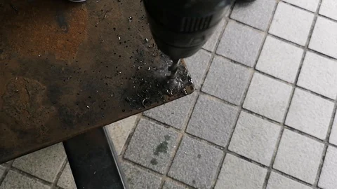 The drill bit is rotating to punch holes in the rusted iron plate. Stock Footage 121305269