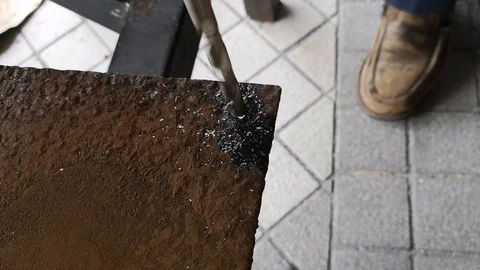The drill bit is rotating to punch holes in the rusted iron plate. Stock Footage 121305312