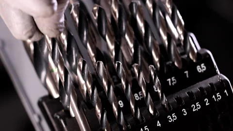 Drill bit selection for metal, with the master’s fingers picking number 10 Stock-Footage 304779623