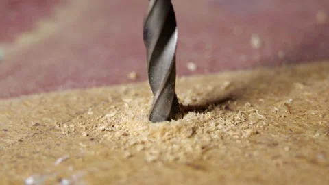 Drill bit slowly drilling MDF board clear cutting sound controlled hand movement Stock Footage 320895504