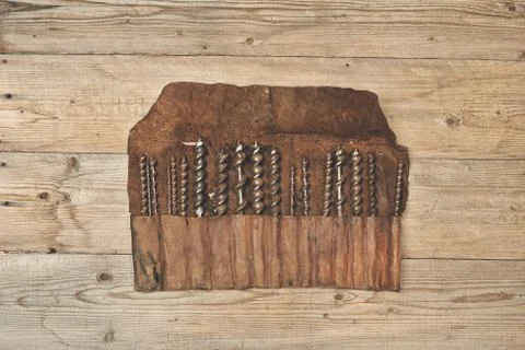Drill bits in leather tool roll on a wooden workbench Stock Photos