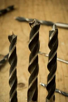 Drill bits on wooden table Stock Photos