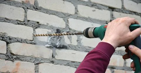 Drill into a brick gray wall Stock Photos