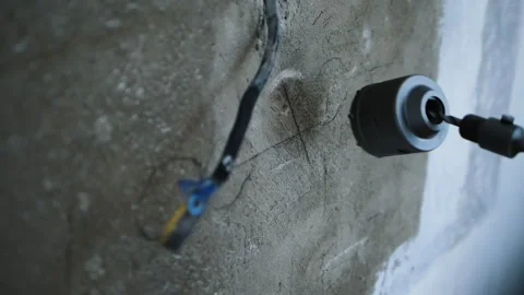 Drill is broken.  A male worker is drilling a socket in the wall with a drill Stock Footage 256504393