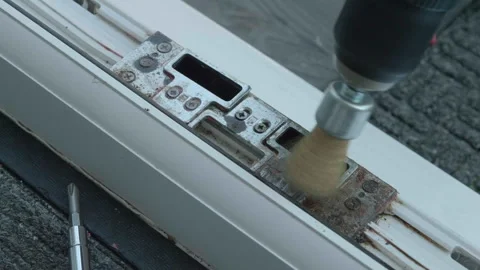 Drill clears rust from door lock mechanism 스톡 동영상 340531590