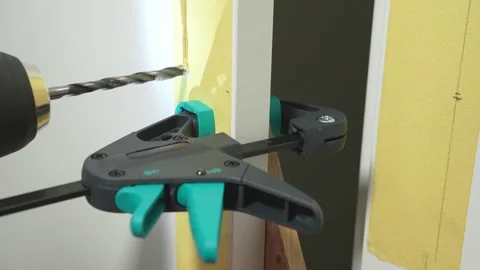 Drill creates a hole in a cabinet door for installing a handle Stock Footage 334808318