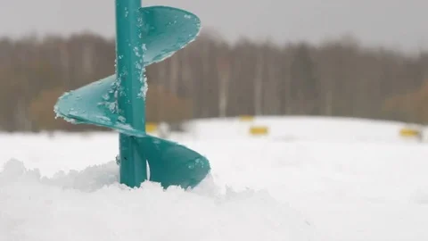 Drill a hole for ice making. Water is poured through the hole. Lake near the Stock Footage 71961566