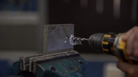 Drill a hole in a steel with a drilling machine at a workshop in slowmotion Stock Footage 203855813