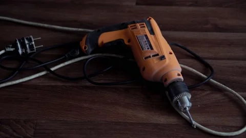 The drill lies on the floor with the wire Stock Footage 153835762