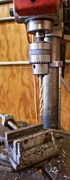 Drill Press With Gold Colored Drill over Vice Stock Photos