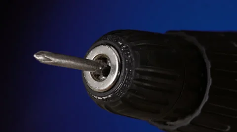 Drill with a screw rotates from zero to maximum speed on blue background Stock Footage 39721454