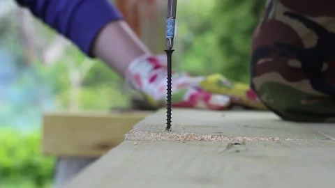 The drill screws a self-tapping screw into the board Stock Footage 135238121