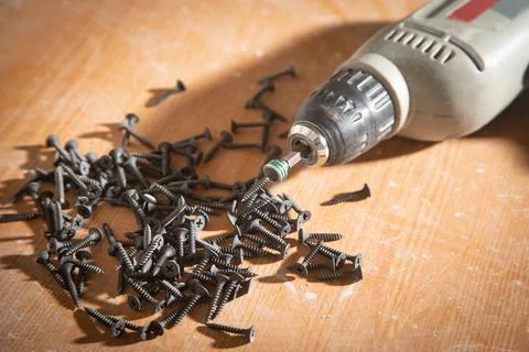 Drill with screws on the table. Stock Photos