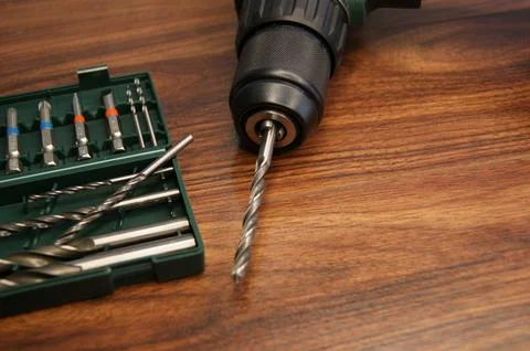 Drill set and drill close-up, carpenter selects drill bit for drilling. Stock Photos