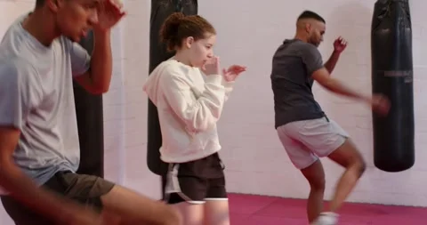 At drill start Diverse training partners punching and front kicking on red mat Stock Footage 342111599