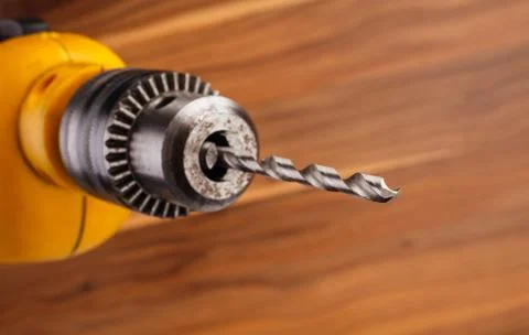 Drill on a wooden background. Stock Photos
