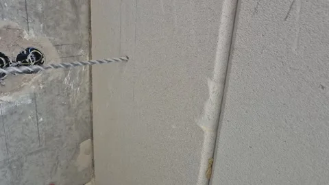 Drilling AC pilot hole into concrete wall close up Stock Footage 338020284