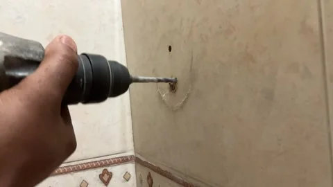 Drilling into a hard tile Stock Footage 328039220