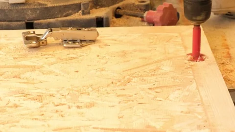 Drilling hinge recess in cabinet door using special cutter. Installing door hing Stock Footage 332875239
