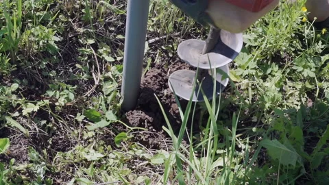 Drilling a hole in the ground with a drilling tool yourself Stock Footage 156543342