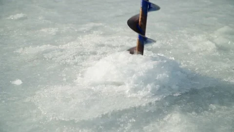 Drilling a hole in the ice with an ice drill. Got on a bump, dirty water went. Stock Footage 238531218
