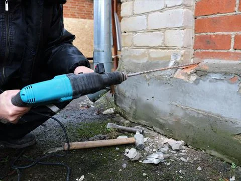Drilling a hole in the outer wall of the house Stock Photos